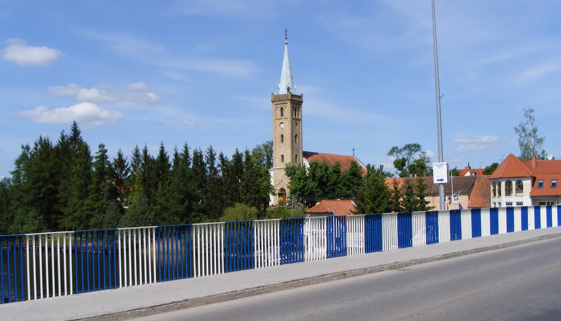 Blick von der Brücke auf die Kirche und die Häuser von Mikołajki in Masuren