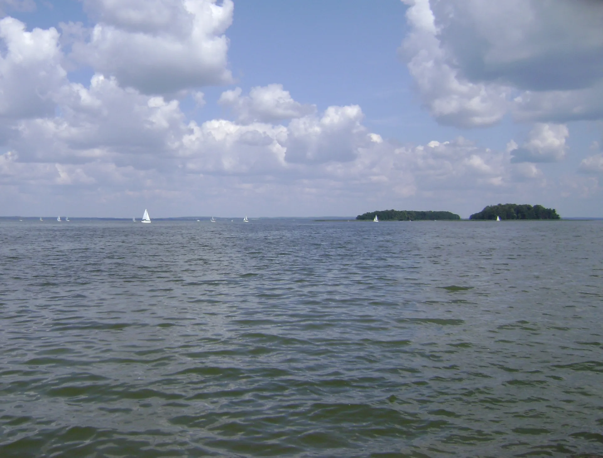 Segelboote und bewaldete Inseln auf dem Śniardwy-See in Masuren